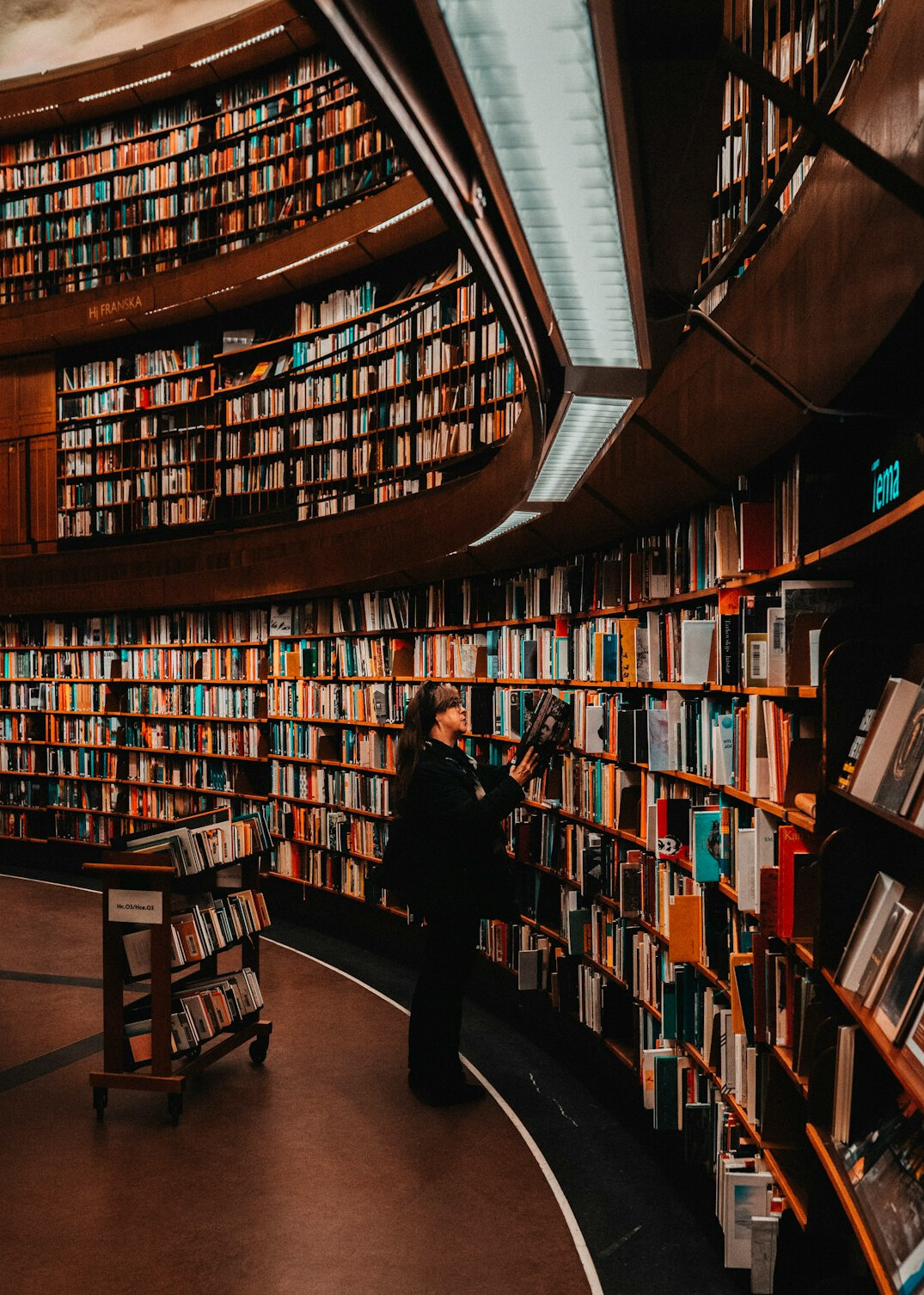 Older Chilean man reading a newspaper in a public library
