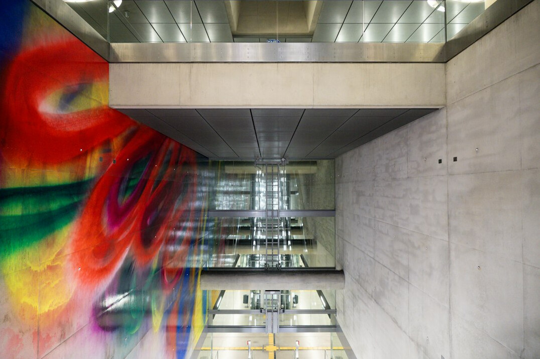 Large colorful mural on a wall in a public passage