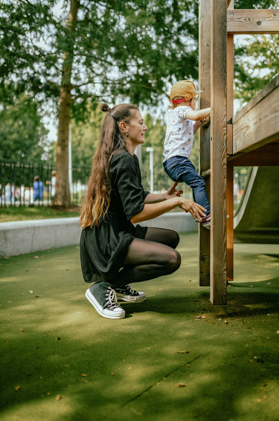 Chilean mother sitting on a park bench with her young daughter