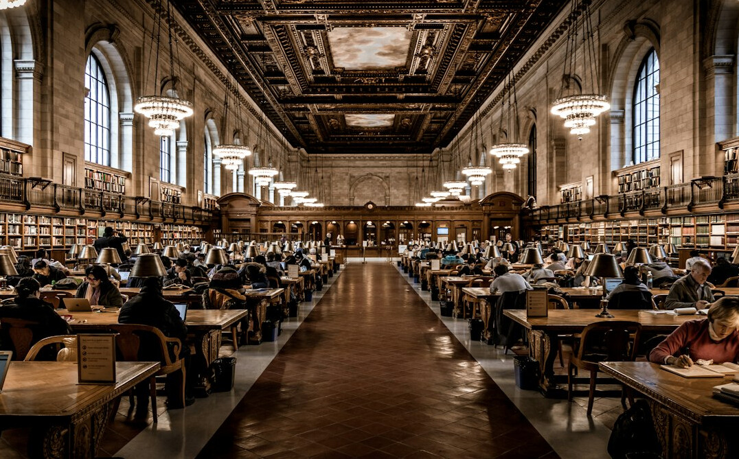 Interior of a public library reading room with people at tables